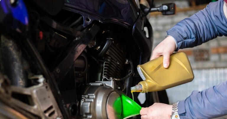 A Person Pouring Oil Into A Motorcycle